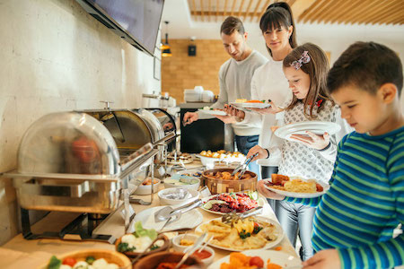 A family of four at a breakfast buffet.