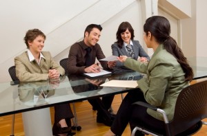 Woman handing over resume at interview.