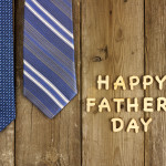 Happy Fathers Day wooden letters on a rustic wooden background with blue ties