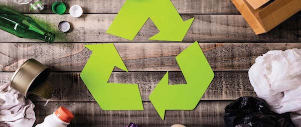 sustainability concept green recycling sign with bottles around it