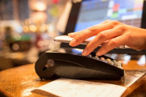 Woman paying with mobile phone, restaurant