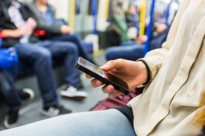 Woman Using Smart Phone in London Tube